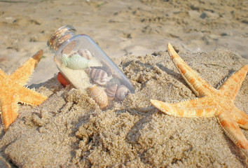 starfish and bottle in sand