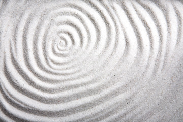 A background patter of a swirl in white sand