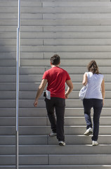 A young couple is walking upstairs.