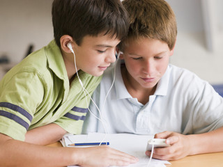 Two Young Boys Distracted From Homework, Playing With MP3