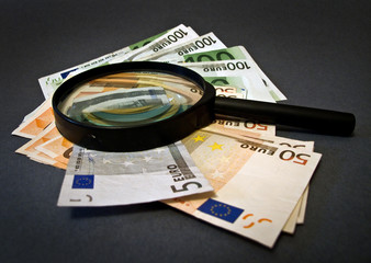 Money And Magnifying Glass