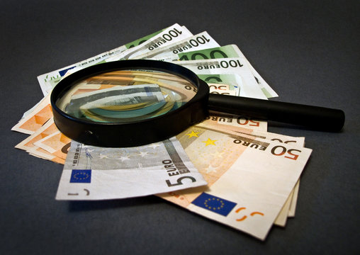 Money And Magnifying Glass