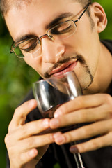 Handsome young man drinking red wine