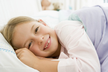 Fototapeta na wymiar Young Girl Lying Down In Her Bed