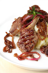 Grilled lamb cutlets, served with mashed potato and red onions