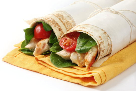 Wrap sandwiches filled with grilled chicken, spinach leaves
