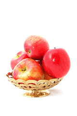 apples in a gold engraved basket isolated on white
