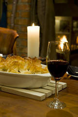 A romantic table setting with candle and fireplace.