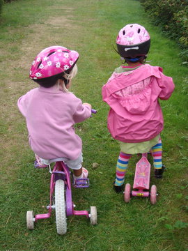 Toddlers cycling next to each other. Best friends cycling