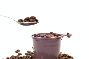 Cup, spoon with coffee beans on white