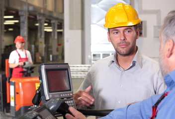 supervisor  talking to forklift operator in warehouse © endostock