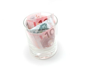 Some euro banknotes in a tumbler isolated on white background