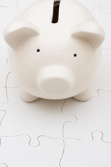 Piggy bank and white puzzle, understanding personal finances