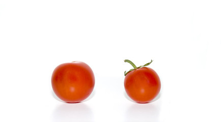 Two Cherry tomatoes with water droplets isolated on white