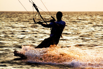 Silhouette of a kitesurfer on a waves