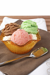 Delicious multi flavor ice cream on wood background. Shallow DOF