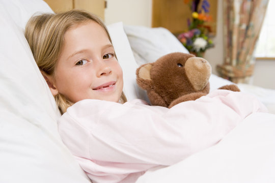 Young Girl Lying In Hospital Bed,Holding Teddy Bear