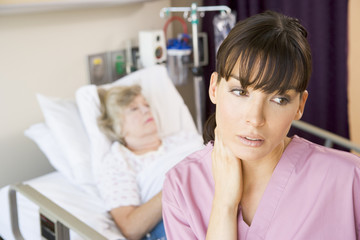 Obraz na płótnie Canvas Nurse Standing In Hospital Room,Looking Tired
