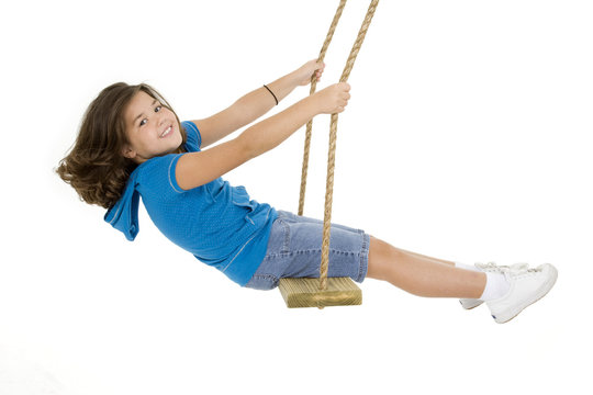 Caucasian child playing on a swing on white background