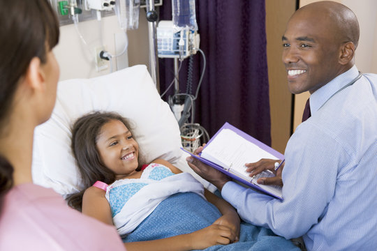 Doctor Making Notes On Young Girl