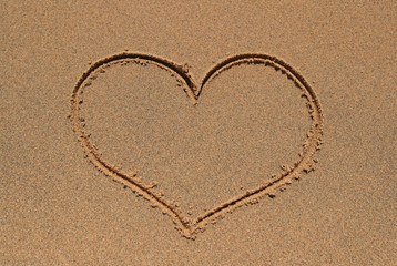 Heart symbol drawn in the sand beach.