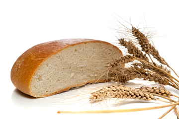 Half of bread loaf and wheat spikes, isolated