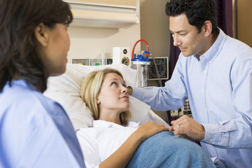 Doctor Talking To Pregnant Woman And Her Husband