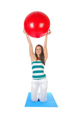 Girl holding bright red colored pilates ball over her head