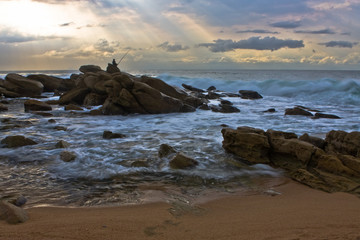Lone fisherman on the rocks overlooking the deep ocean
