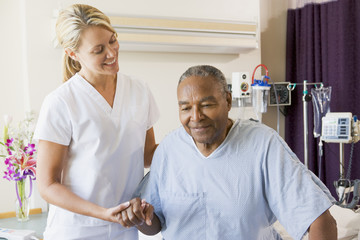 Nurse Helping Senior Man To Walk - Powered by Adobe