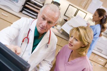 A Doctor And Nurse Discussing Something At The Reception Area Of