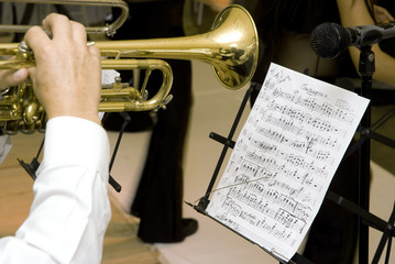A music score and a musician whit trumpet