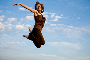 Obraz premium girl dancing of joy over blue sky