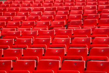 many plastic red seat in deserted stadium