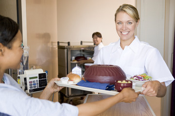 Nurse Serving A Patient A Meal In Her Bed