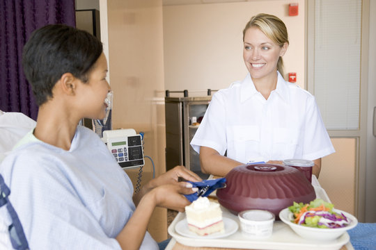 Nurse Serving A Patient A Meal In Her Bed