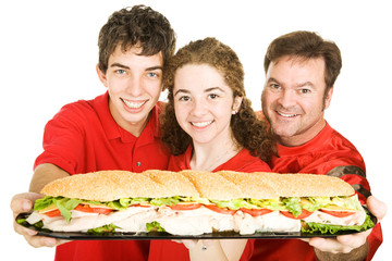 Football fans holding a giant submarine sandwich.  Isolated