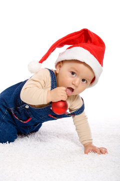 One year old baby boy in santa's hat, smiling.