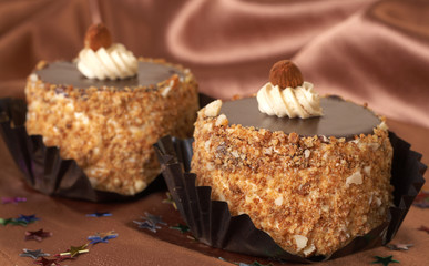 Two miniature chocolate meringue cakes with cream