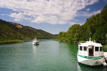 two white pleasure boats and river among the green hills
