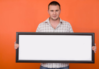 casual guy standing with banner on orange background