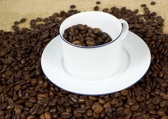 Kaffetasse mit Kaffebohnen vor weißem Hintergrund