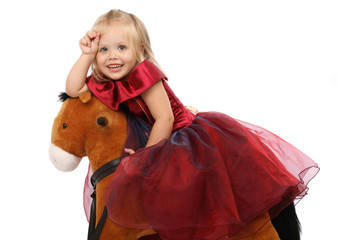 Portrait of the beautiful girl on a toy horse