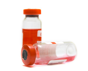 Transparent ampules with a red medicine on a white