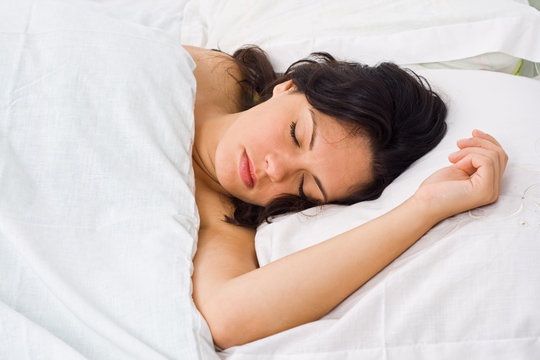 A young woman sleeping in bed alone