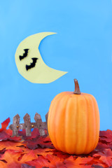 golden leafs and pumpkin by fence with bats and moon