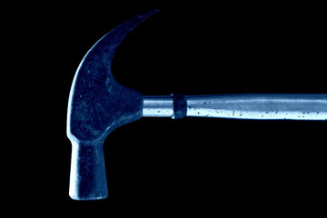 Rusted old hammer against black background, in blue tone.
