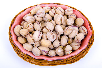 Pistachio nuts in a bowl isolated on white