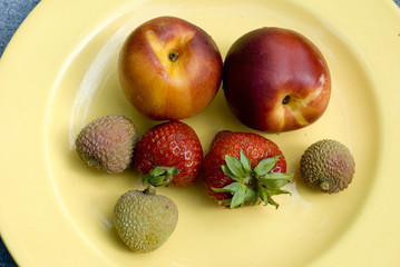 Nectarines, strawberries and lychees on a plate