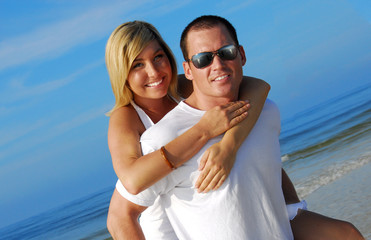 Handsome man and pretty woman having fun at beach - 9395637